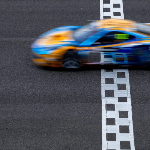 Motion blur race car racing on speed track, Car race on the international circuit race track crossing start and finish line, Race car on road crossing start and finish line, Target business achieve victory concept. Motion blur race car racing on speed track, Car race on the international circuit race track crossing start and finish line, Race car on road crossing start and finish line, Target business achieve victory concept.